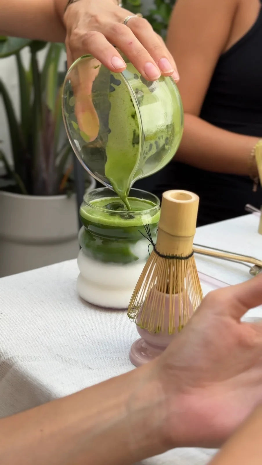 Pouring matcha into a glass of milk